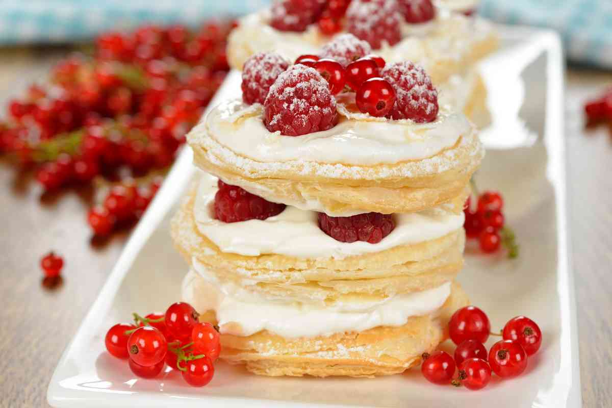 millefoglie con crema e lamponi monoporzione in un vassoio rettangolare