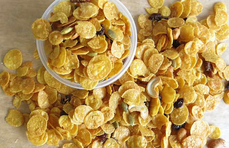 Dei cornflakes in una ciotola e su un tavolo