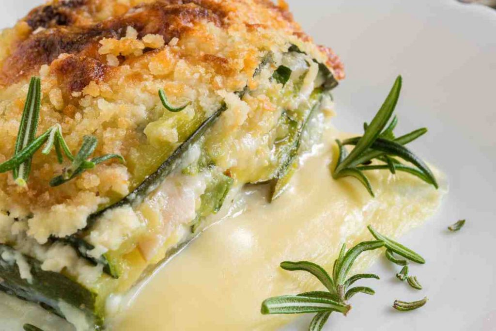 Parmigiana di zucchine con besciamella in un piatto