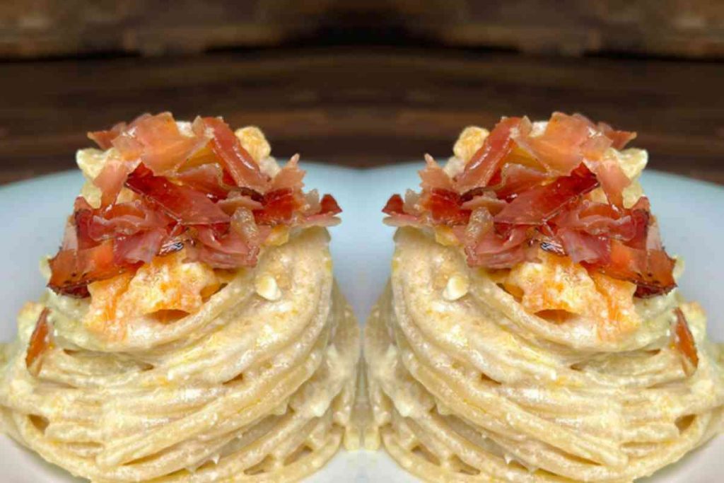 Pasta al melone feta e speck raccolta a forma di nido in un piatto