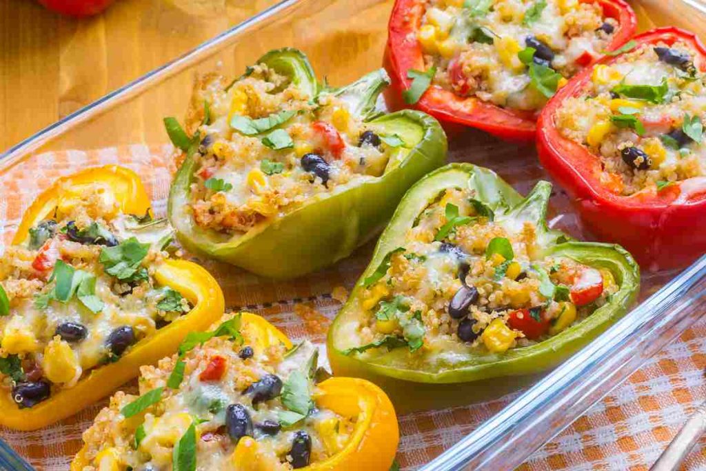 Peperoni ripieni quinoa e verdure in una teglia