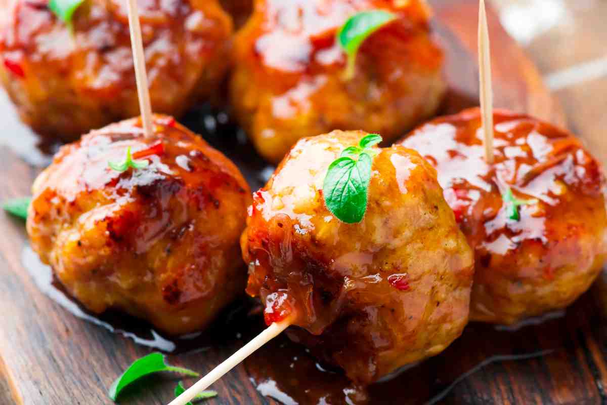 primo piano delle polpette di pollo glassate infilzate con gli stecchini