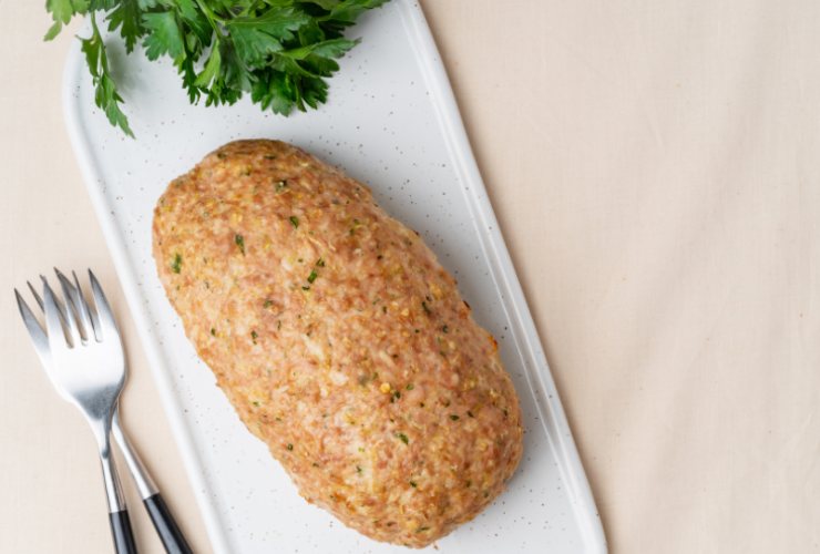 Polpettone di carne bianca con forchette e prezzemolo