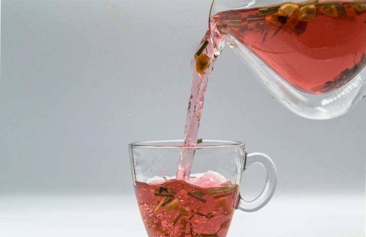 Del tè versato da una brocca in una tazza