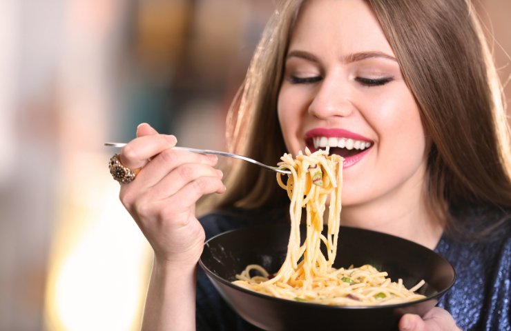 Una dona che mangia degli spaghetti