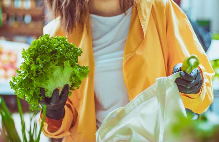 Una donna che sceglie una insalata fresca