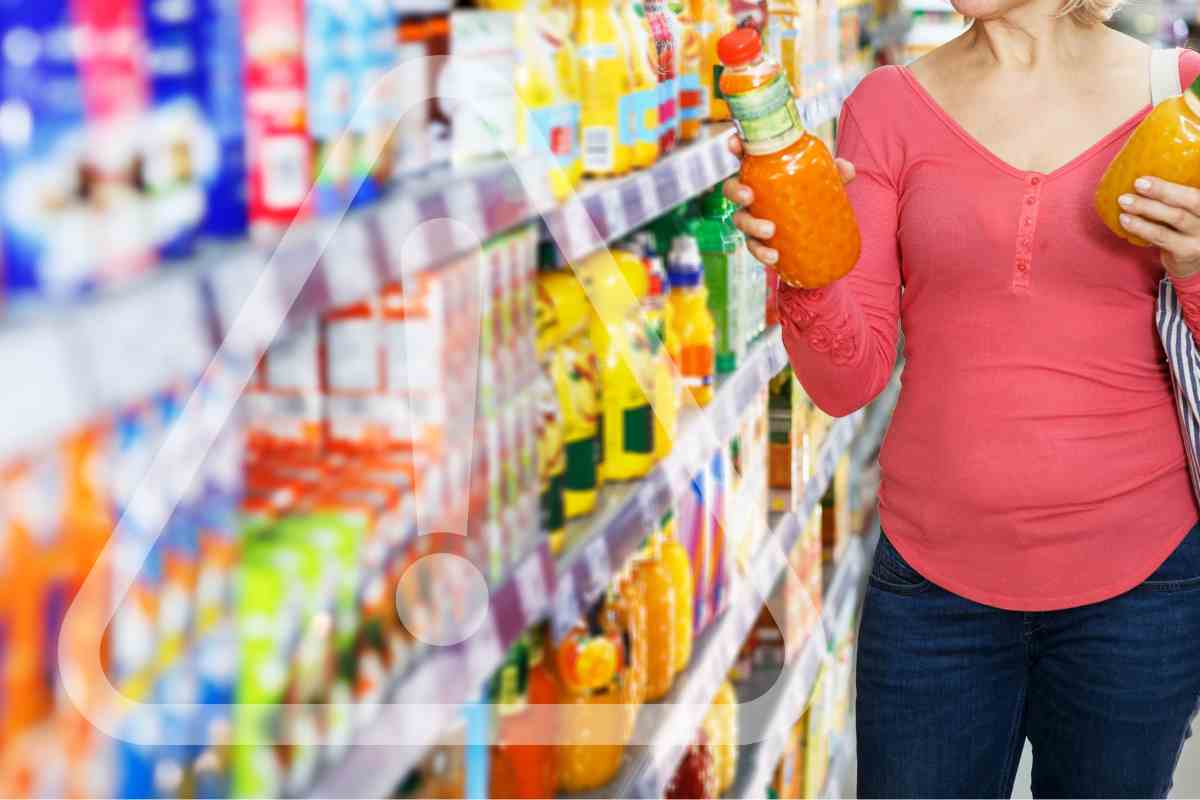 Una donna che sceglie delle bevande al supermercato