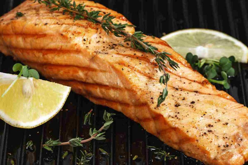 Salmone grigliato sulla piastra con fettine di limone