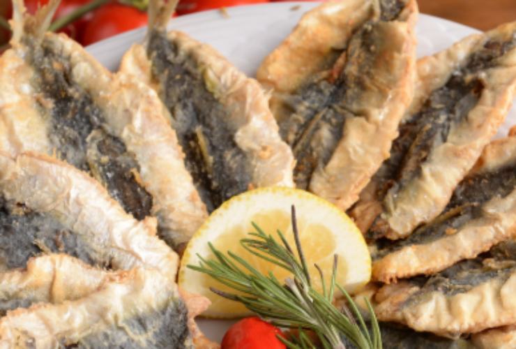 Sarde fritte con limone e rametto di rosmarino