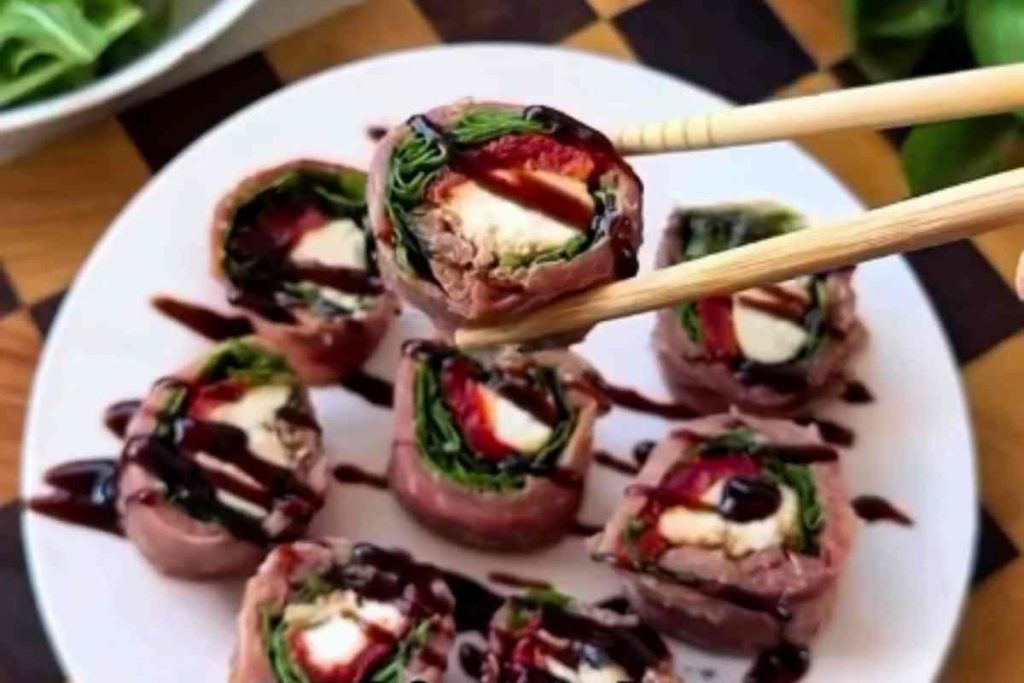 piatto con sushi napoletano e bacchette che reggono un rotolino