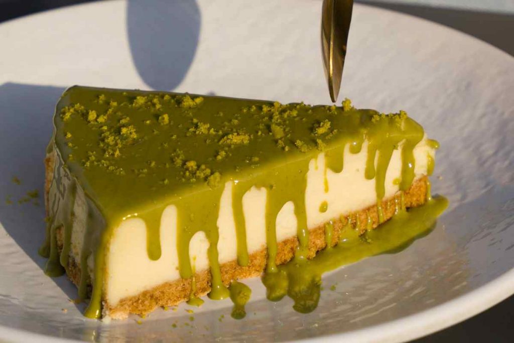 fetta di torta fredda al pistacchio in un piatto con sopra un cucchiaino