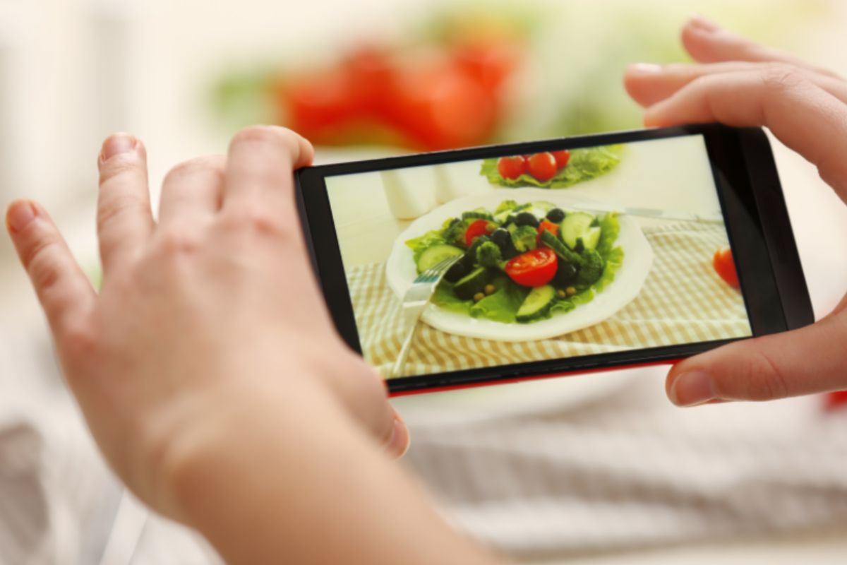 persona che con il cellulare fa una foto ad un piatto