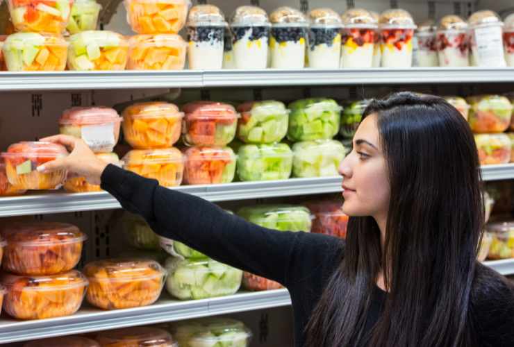 ragazza prende la frutta confezionata