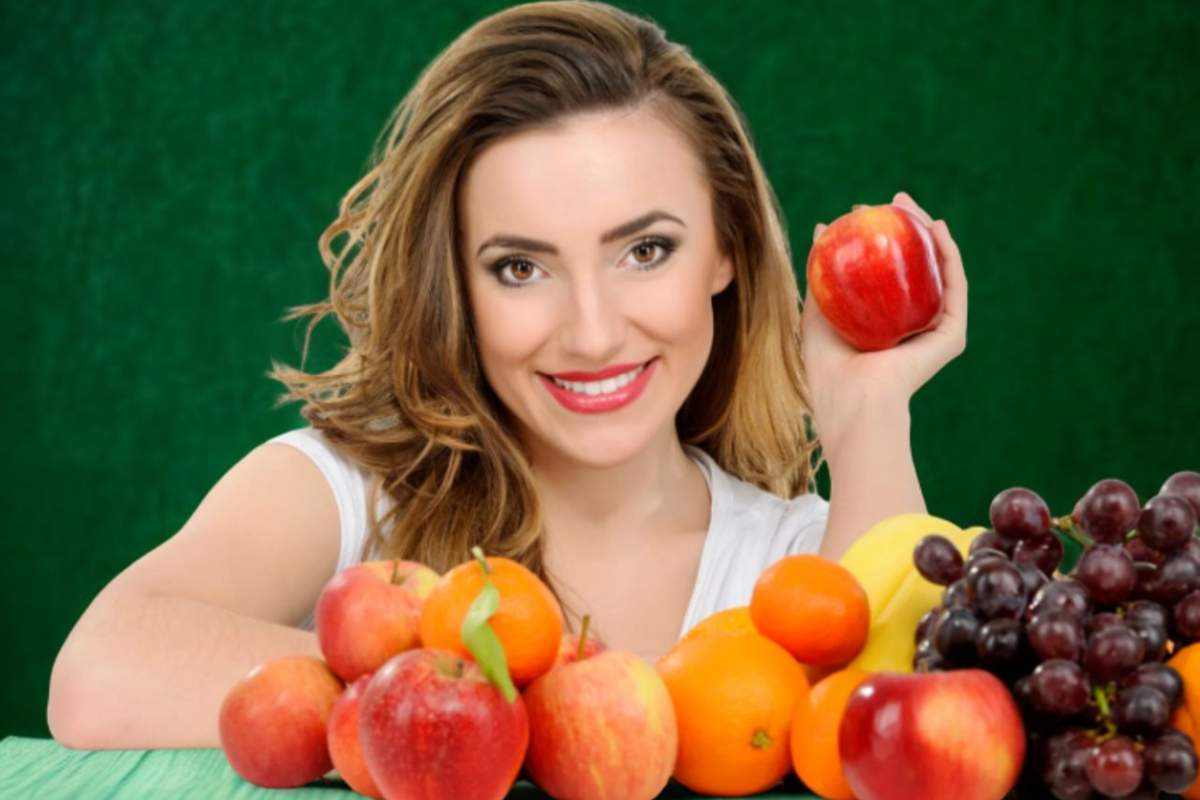 donna che tiene in mano un frutto e davanti dell'altra frutta