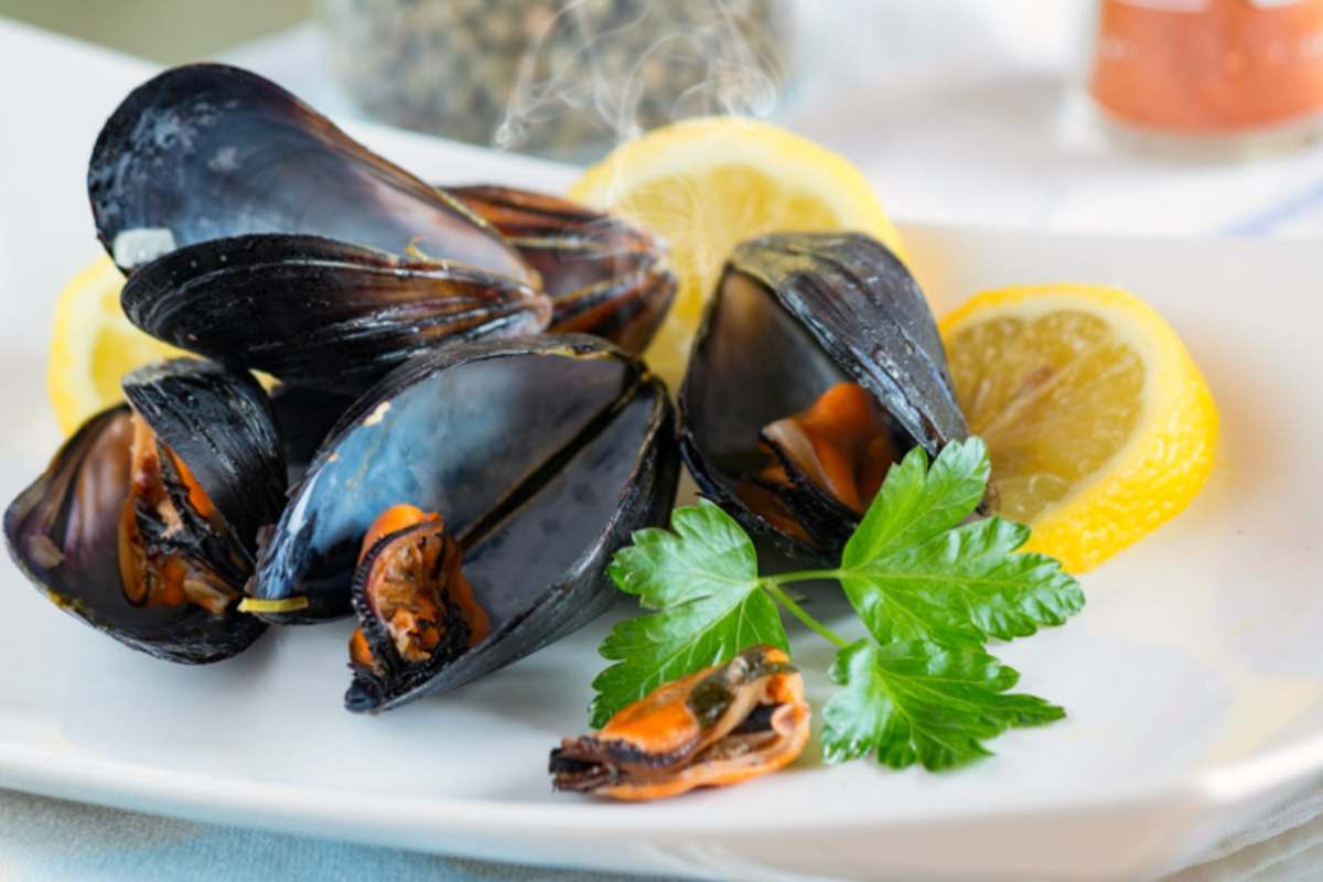 cozze in un piatto con limone