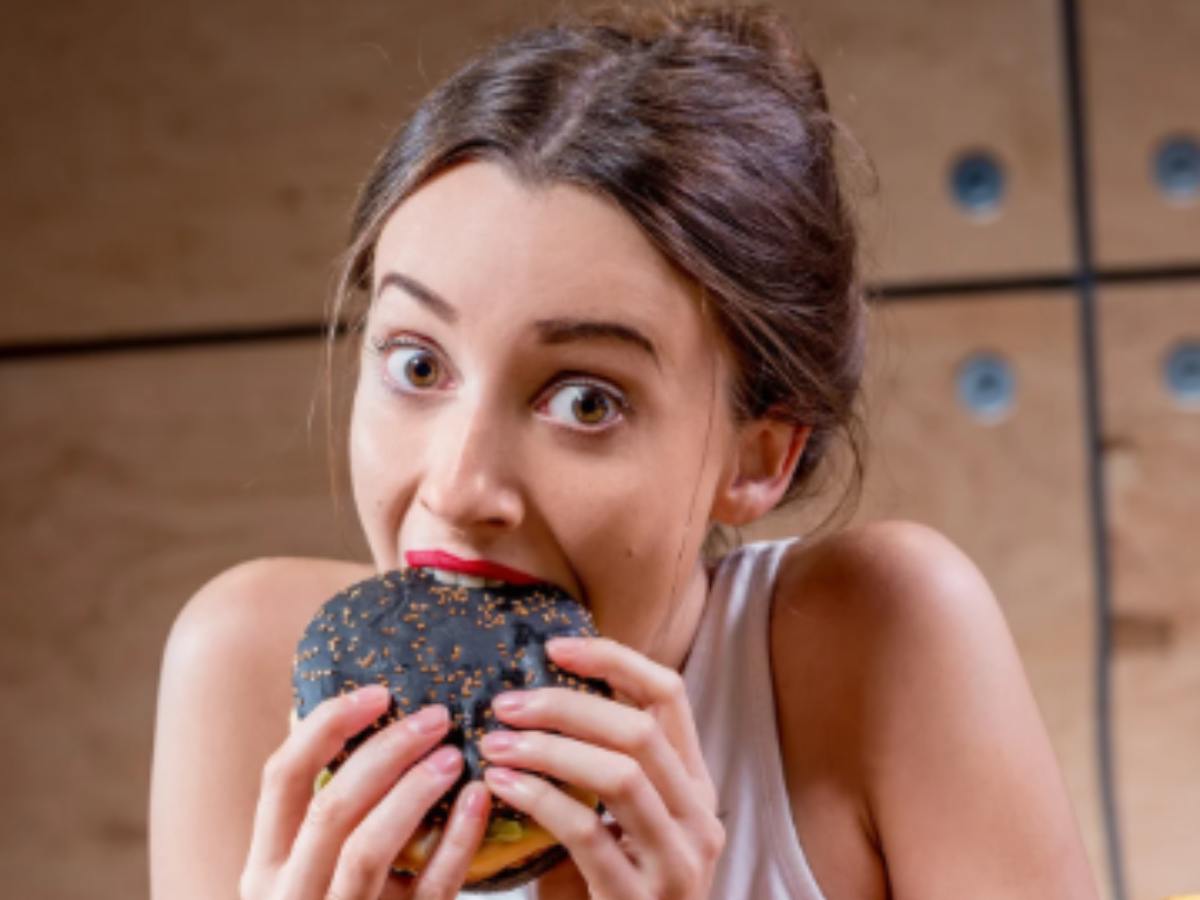 donna che mangia un hamburger