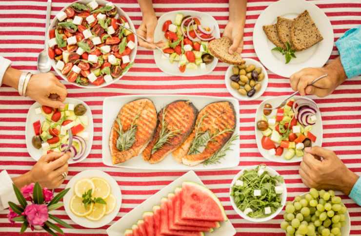 persone che mangiano verdure frutta e pesce