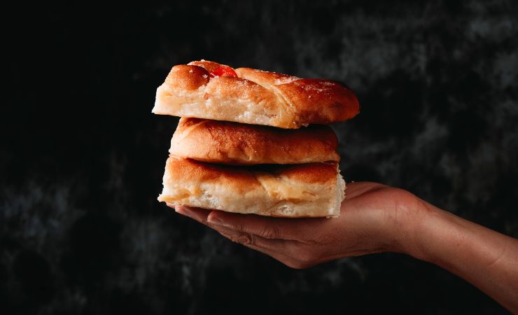 pezzi di focaccia dolce in mano