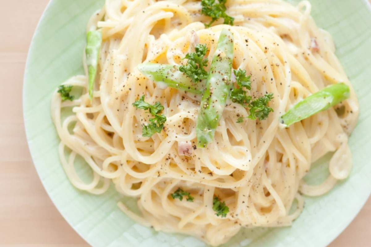 piatto di spaghetti cremoso con erbe aromatiche