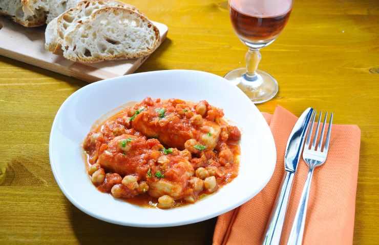 baccalà con ceci e pomodori su tavola
