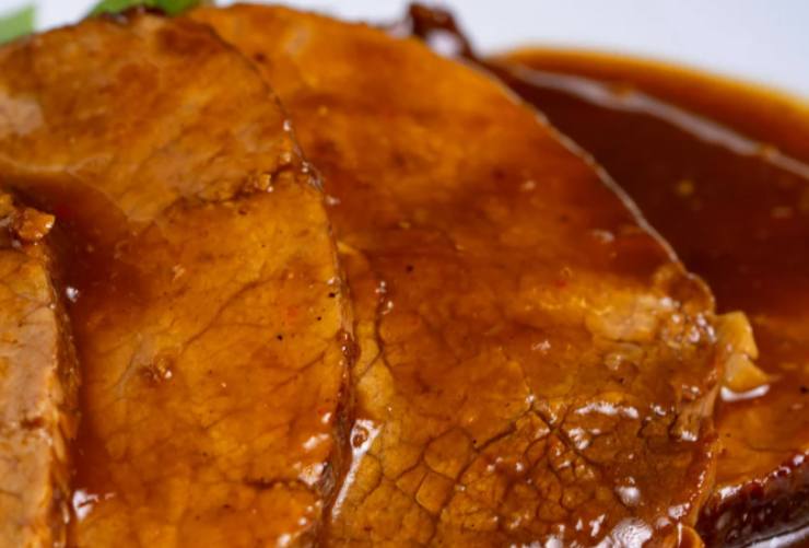 primo piano di carne con sugo di pomodoro