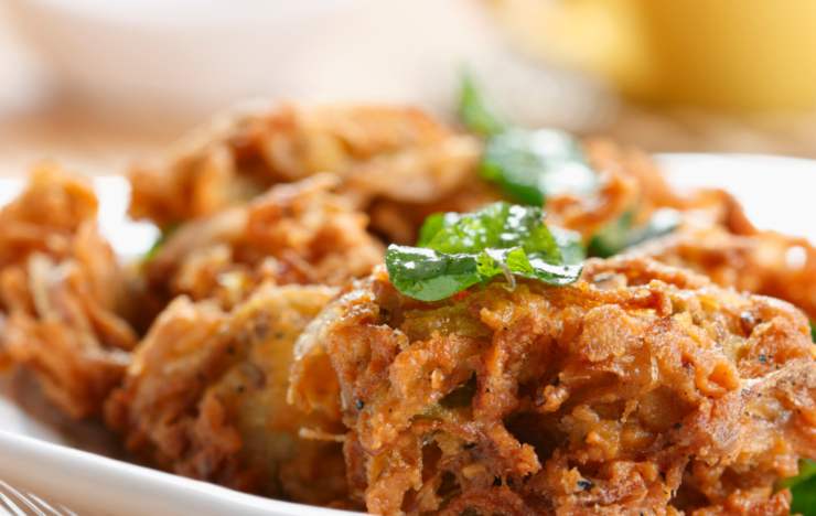 primo piano di frittelle di cipolle dorate