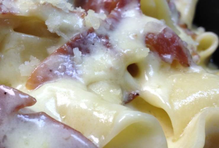primo piano di pasta cremosa con patate e speck