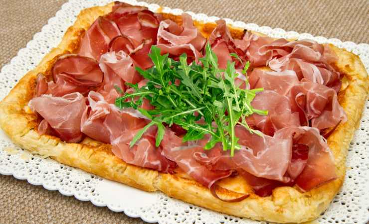 torta salata speck e rucola su vassoio