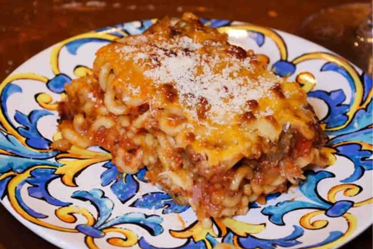 piatto con decorazioni siciliani sopra al quale c'è una porzione di anelletti al forno