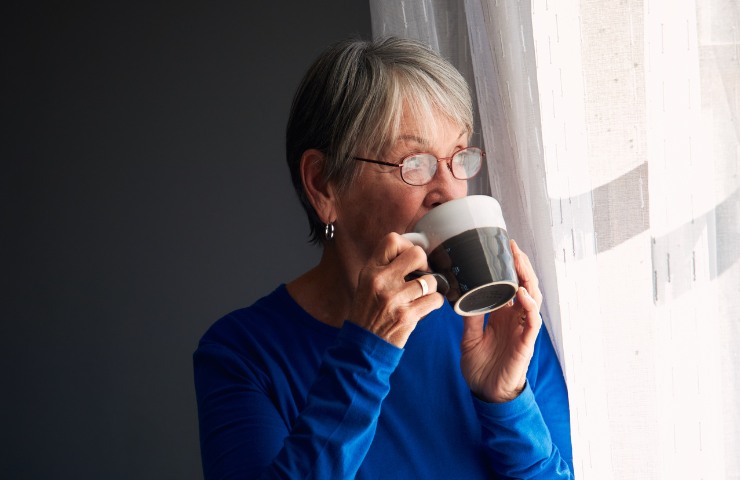 Anziana che beve del caffè