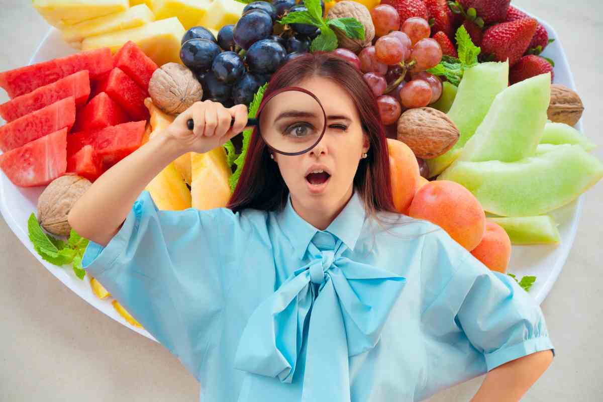 Una donna curiosa e frutta estiva sullo sfondo