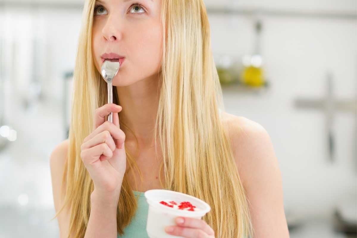 Una ragazza che mangia uno yogurt