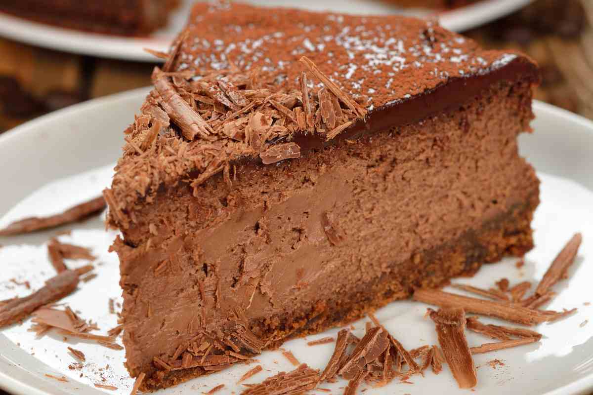 fetta di cheesecake alla Nutella in un piatto decorato con riccioli di cioccolato