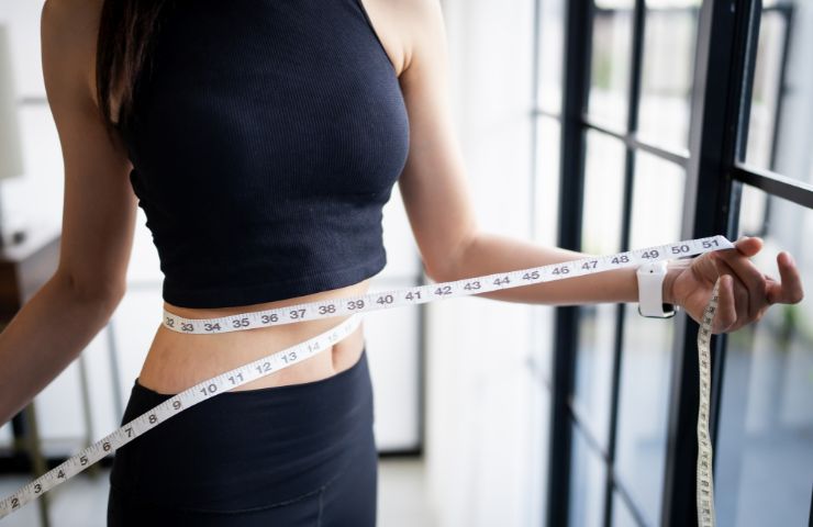 Una donna che misura il suo girovita