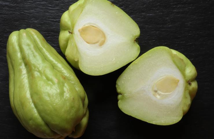 Un chayote intero ed uno affettato