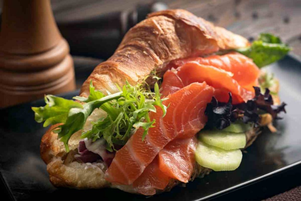 Cornetto salato con avocado e salmone in un piatto