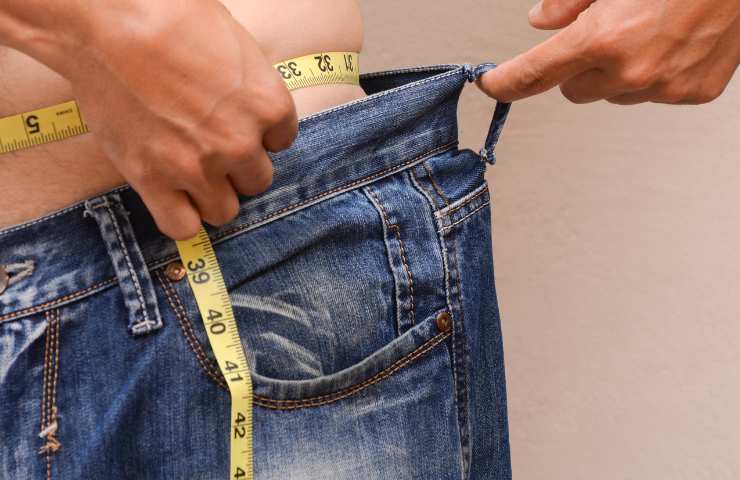 Una persona che misura il proprio girovita