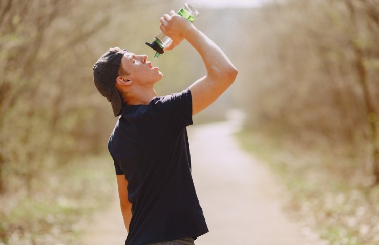 Un uomo che beve all'aperto