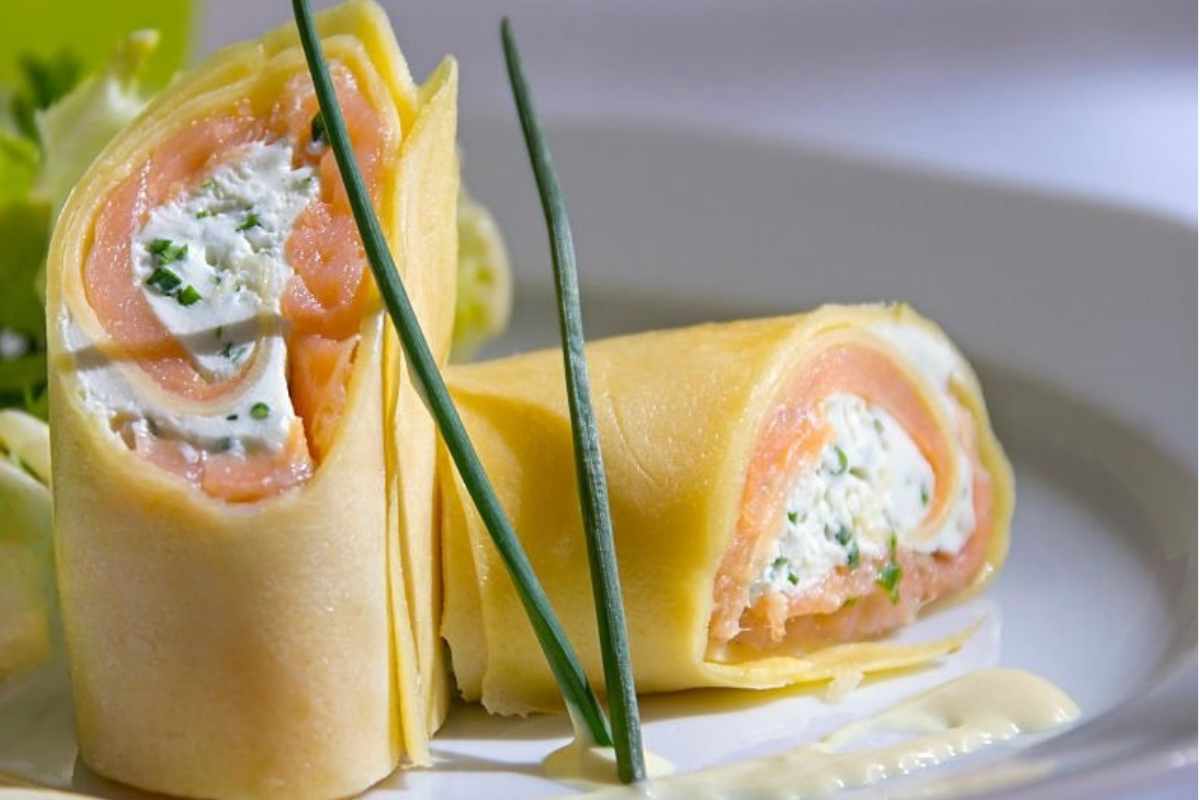 Delle crepes al salmone farcite in un piatto