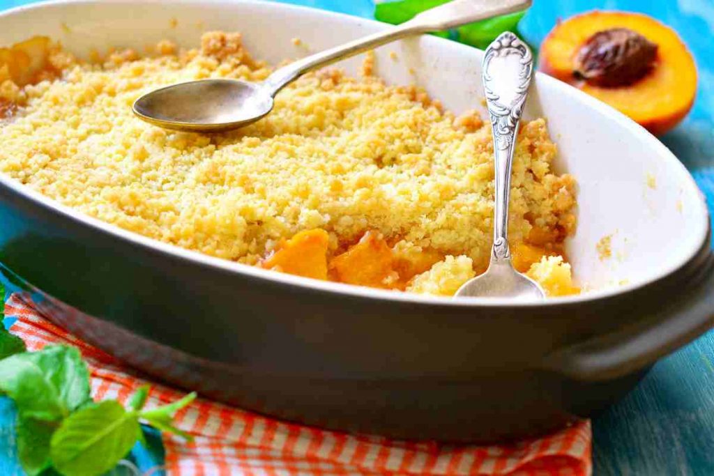 Crumble con le pesche in una pirofila