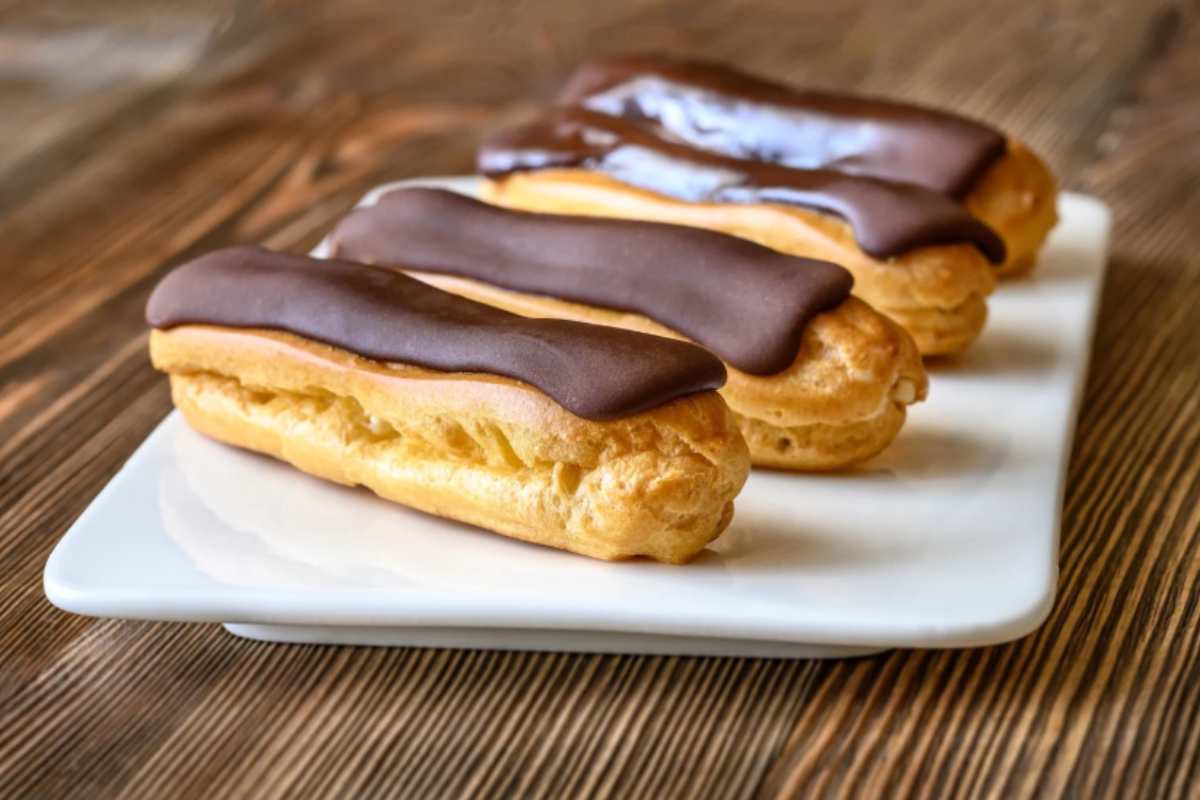 Eclair al cioccolato in un vassoio bianco
