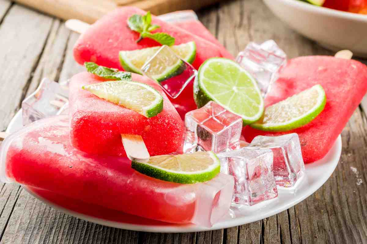piatto con diversi ghiaccioli alcolici al cocomero e fette di lime