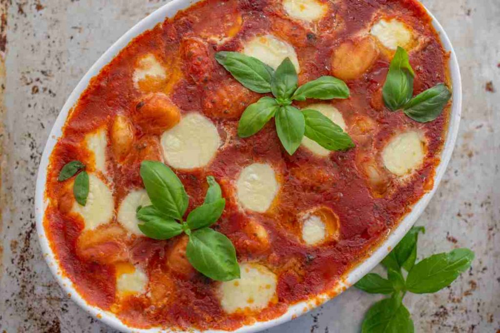 Gnocchi al forno al sugo e mozzarella in una pirofila vista dall'alto