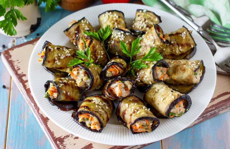 Involtini di melanzane con robiola e noci serviti in un piatto