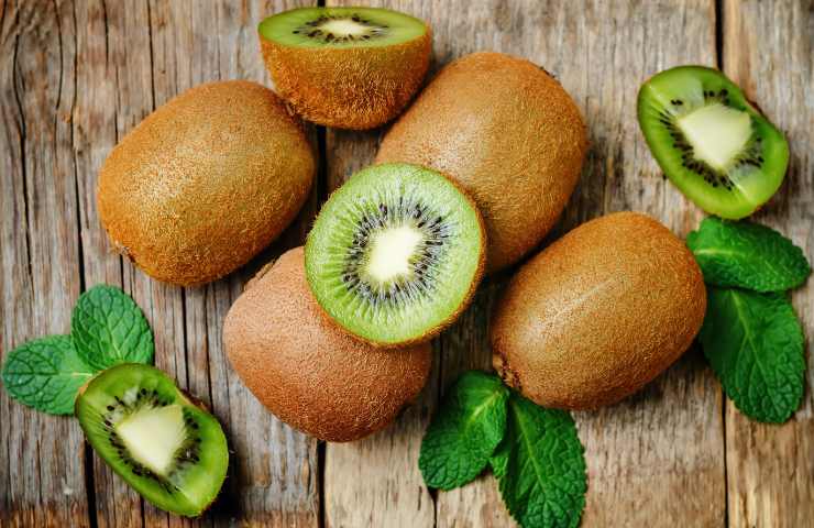Dei kiwi interi ed affettati su un tavolo