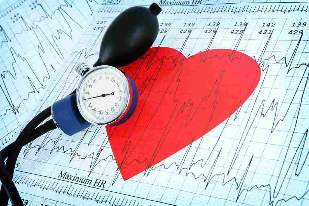 Un cuore su un elettrocardiogramma ed uno strumento per la pressione arteriosa