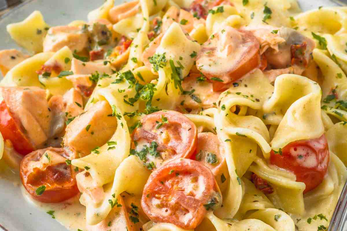 piatto con pappardelle con crema di salmone, salmone e pomodorini visto da vicino