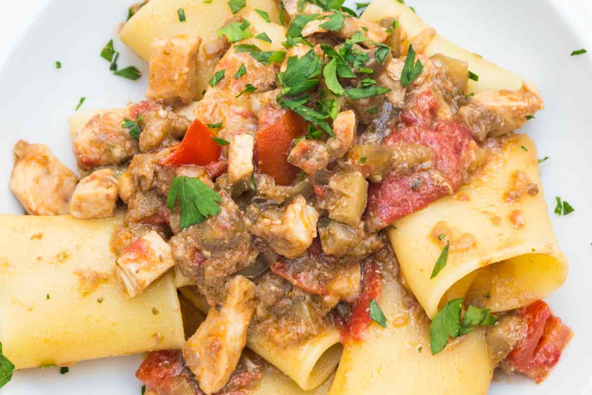 Pasta con pesce spada e pomodorini in un piatto vista dall'alto