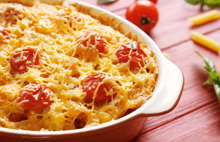 Una porzione di pasta al forno con feta e pomodorini