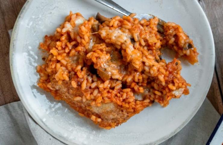 Una porzione di riso al forno con melanzane in un piatto
